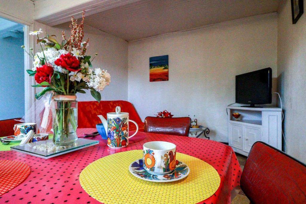 a room with a table with a vase of flowers at Les platanes in Aignes