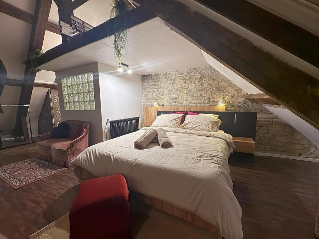 a bedroom with a large bed and a brick wall at Caen duplex T2 confort 18è s coeur de ville avec Vayny in Caen