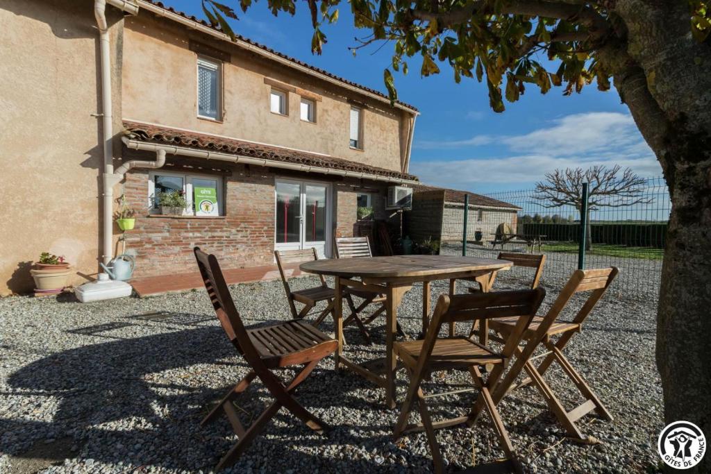 een tafel en stoelen voor een huis bij Saint martin 2 in Beaumont-sur-Lèze