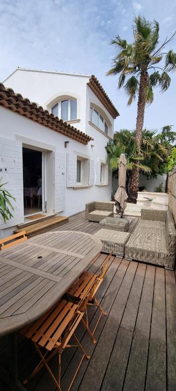 une table en bois devant une maison dans l'établissement Maison de bord de mer ,Hyères, 3 chambres, jardin, calme, à Hyères