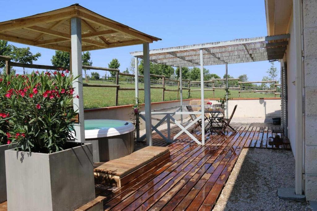 a wooden deck with a hot tub and a pavilion at Villa les paradoux in Pin-Balma