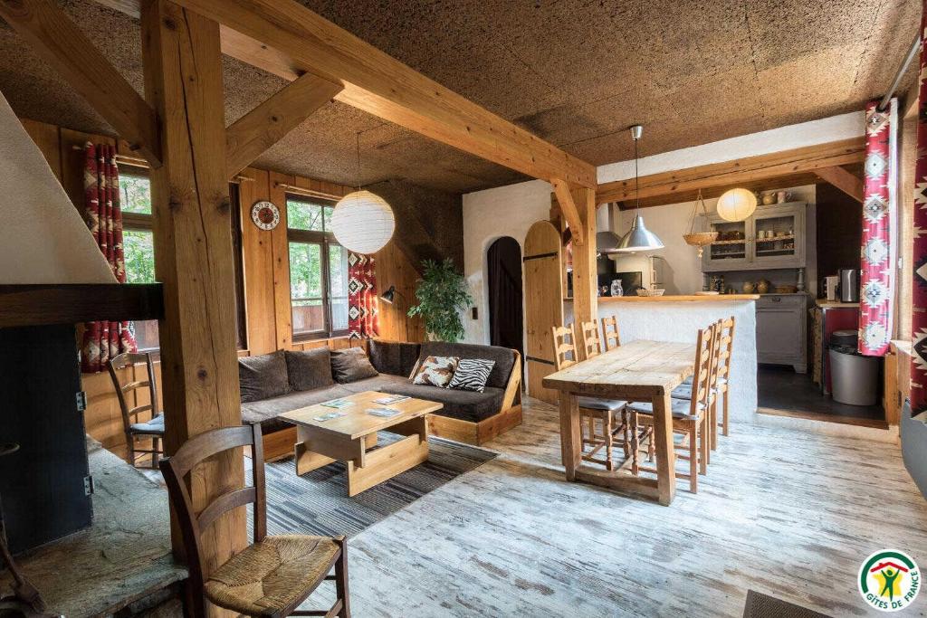 a living room and kitchen with a table and a couch at Le gîte de la coume in Garin