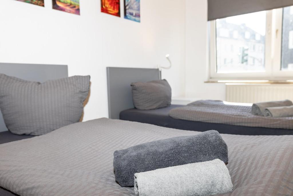 a bedroom with two beds with pillows and a window at CosyHomes24 - Centrally with balcony and parking space - GE09a in Gelsenkirchen