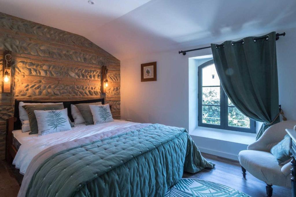 a bedroom with a large bed and a window at Le sourire des anges 2 in Saint-Élix-le-Château