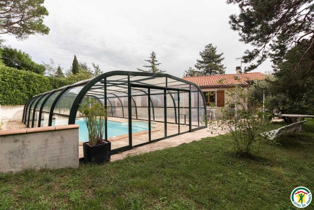 a pool in a greenhouse next to a house at La maison imart in Revel