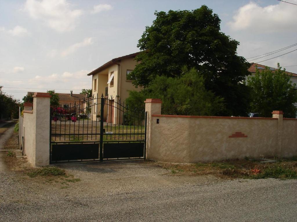 a gate in front of a house with a fence at Les hortensias in Aussonne