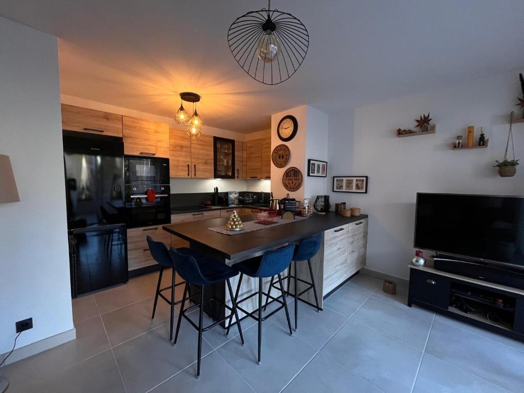 une cuisine avec une table et des chaises et une télévision dans l'établissement Azur Plage, à Fréjus