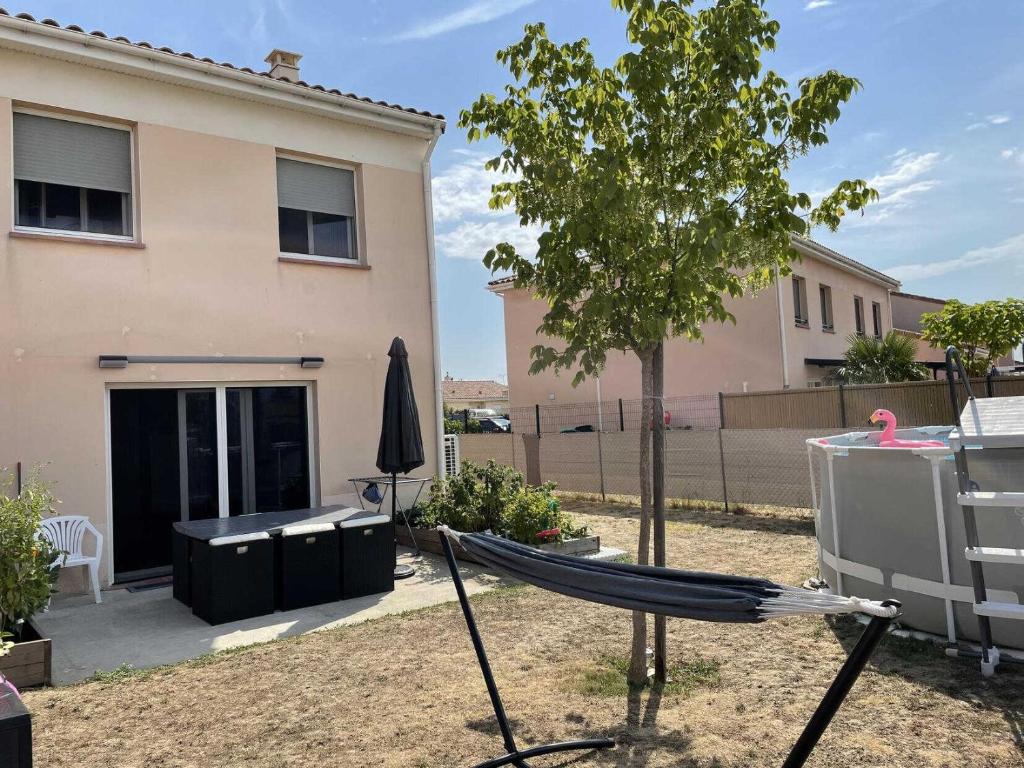 a hammock in a yard in front of a house at La maison d'emy in Vernet