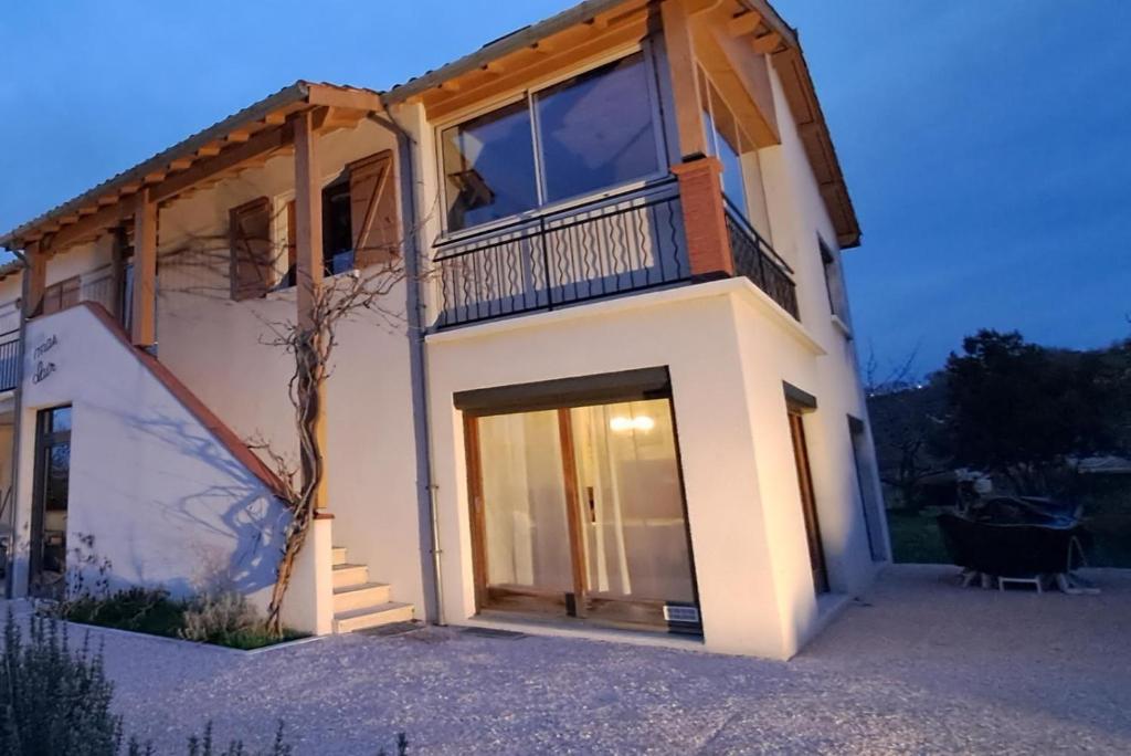 a large white house with a balcony on top of it at Le mas clair in Pins-Justaret