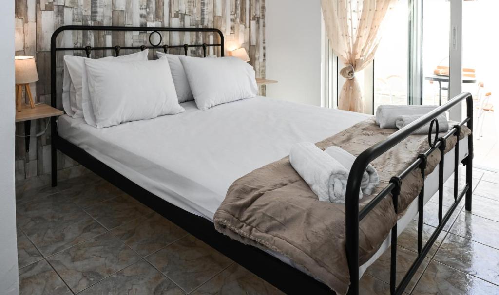 1 cama con marco de metal y almohadas blancas en Casa 30 House Complex Center of Ialysos, en Ialisos