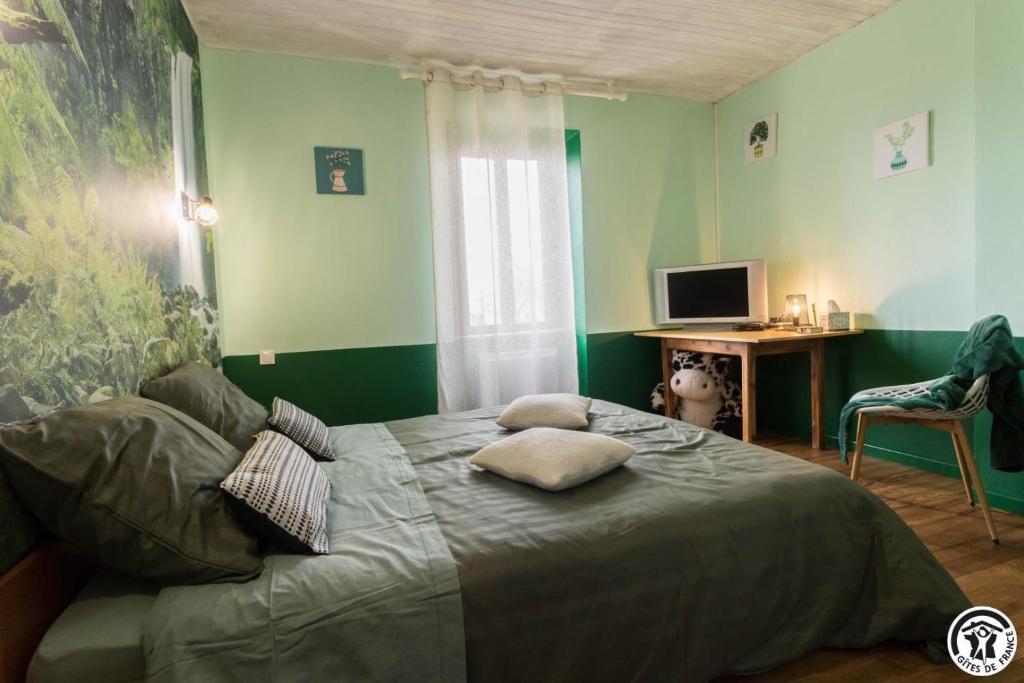a bedroom with a bed with pillows on it at Comà a l'ostal in Montégut-Lauragais