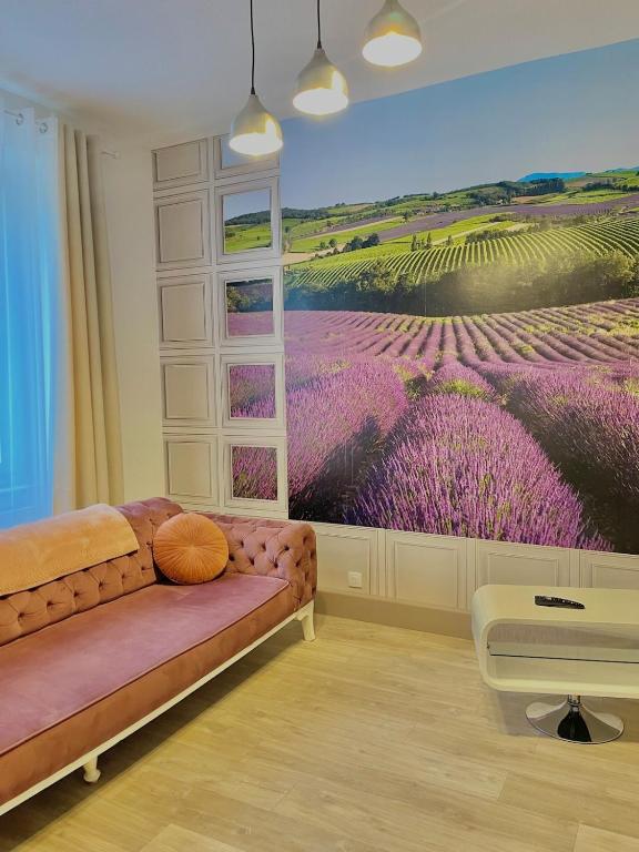 un salon avec une fresque de fleurs violettes sur le mur dans l'établissement L'universal Provençal au coeur de Mulhouse, à Mulhouse