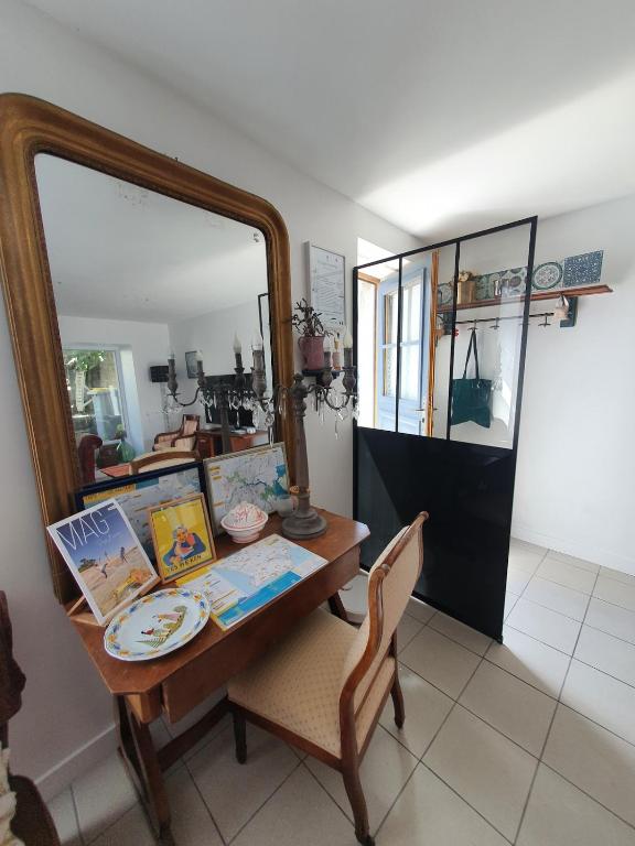 Cette chambre comprend une table avec un miroir et une chaise. dans l'établissement Maison historique - cour - centre-ville -plage 10 mn, à Pont-lʼAbbé