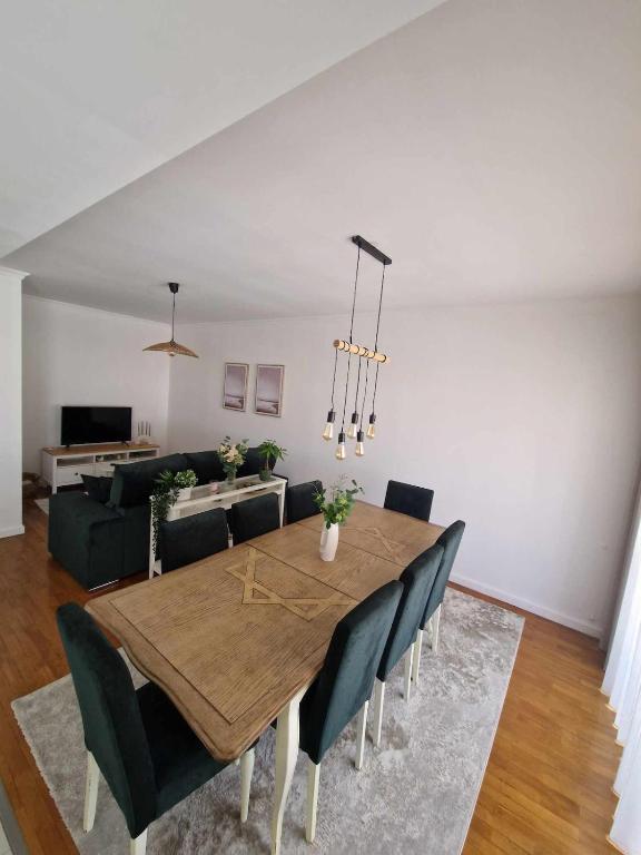 a dining room with a table and a couch at apartamento Bitarães Paredes in Bitarães