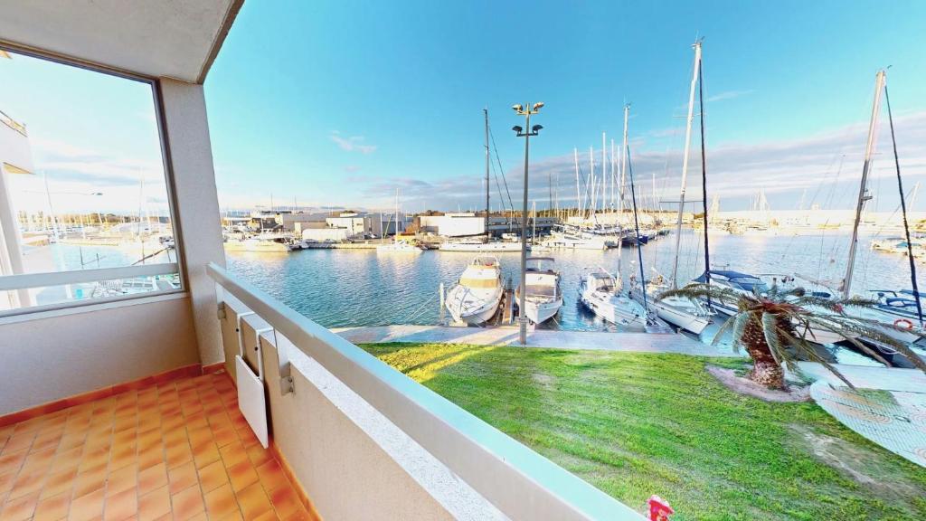 un balcon avec vue sur une marina avec des bateaux dans l'établissement appartement 4 personnes vue sur la marina, à Canet