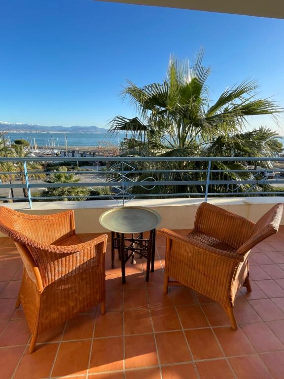 d'une terrasse avec des chaises en osier et une table sur un balcon. dans l'établissement Belvédère 3 étoiles, à Antibes