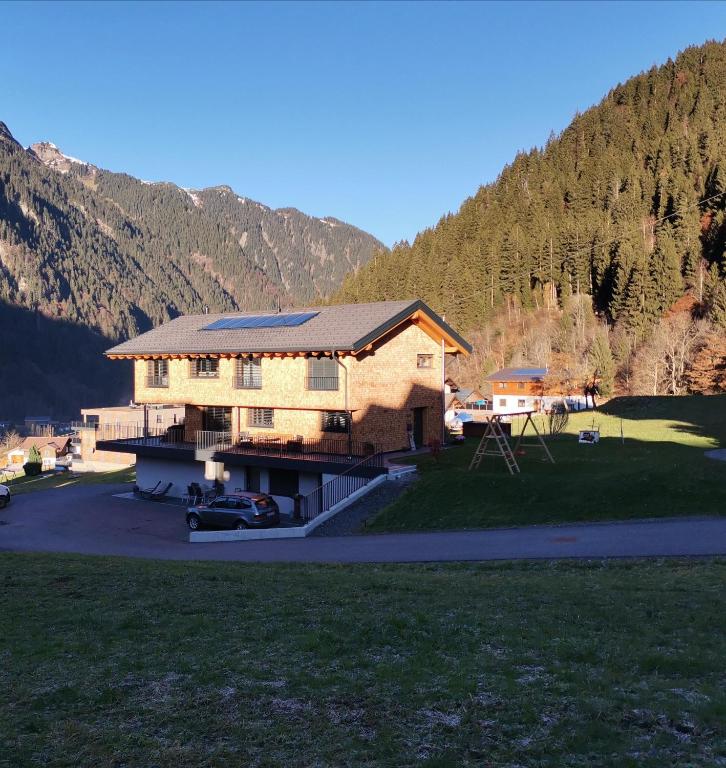 a large house with a mountain in the background at Apart Blasblei in Sankt Gallenkirch