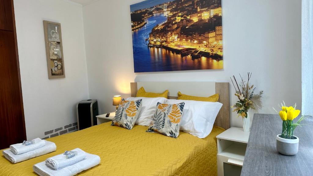 ein Schlafzimmer mit einem gelben Bett mit Handtüchern darauf in der Unterkunft Almeida's House by Férias em Figueira in Figueira da Foz