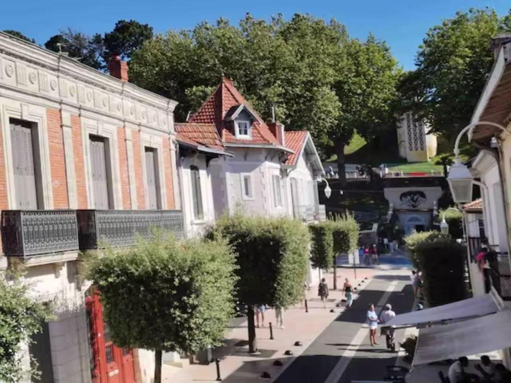 une rue de la ville avec des maisons et des gens qui marchent dans la rue dans l'établissement T2 Centre Plage Arcachon, à Arcachon
