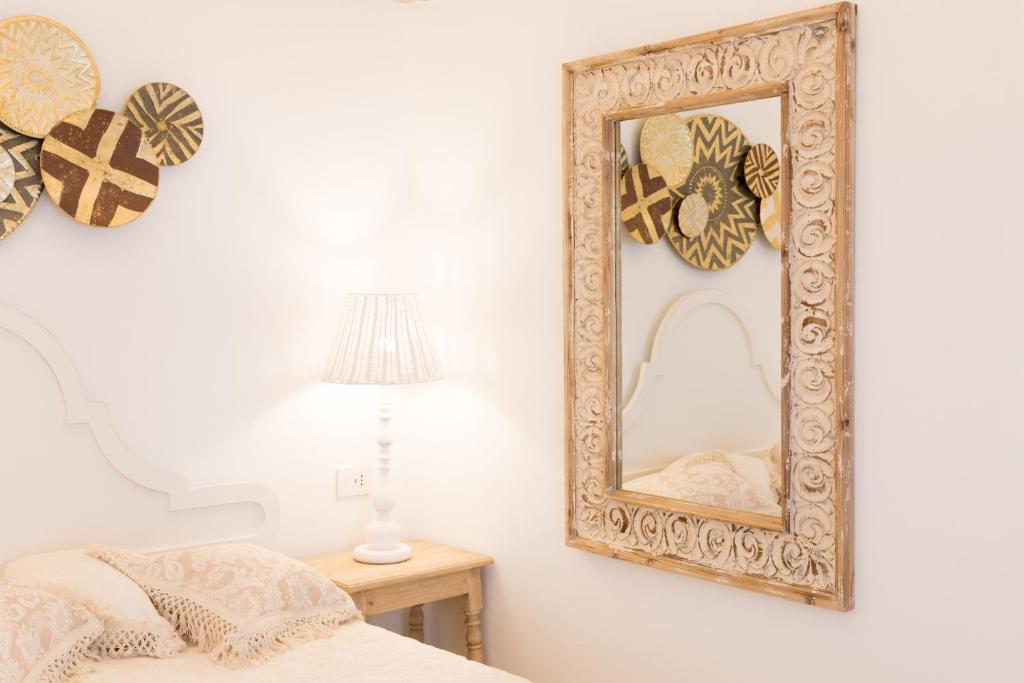 un miroir sur un mur à côté d'un lit dans l'établissement Dimore Trulli Holiday, à Alberobello