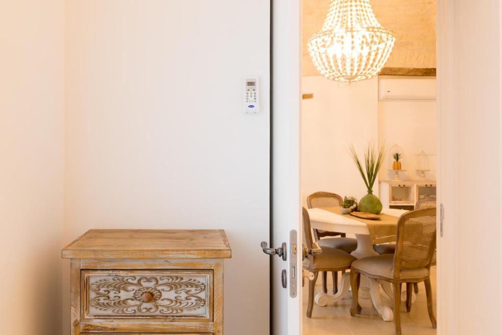 une salle à manger avec une table et un lustre dans l'établissement Dimore Trulli Holiday, à Alberobello