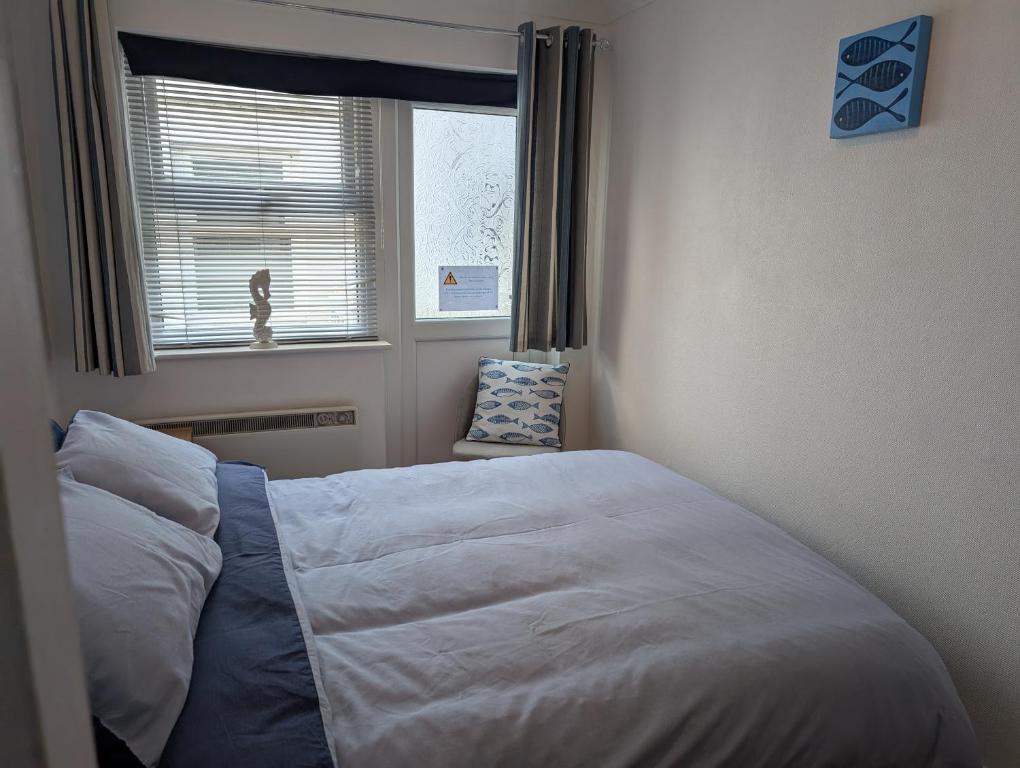 a bedroom with a bed and a window and a chair at Bijou in St Ives