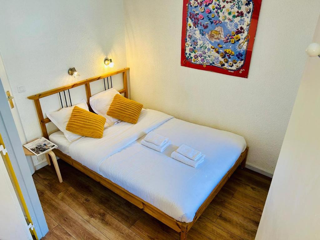 Un dormitorio con una cama con almohadas amarillas. en Appt cosy au centre de Chamonix, en Chamonix-Mont-Blanc