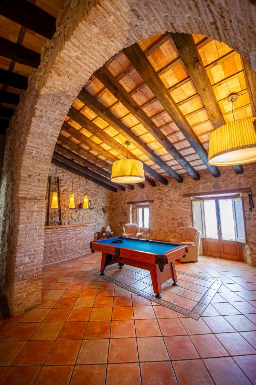 a pool table in a room with a brick wall at La Masia in Sant Pau dʼOrdal