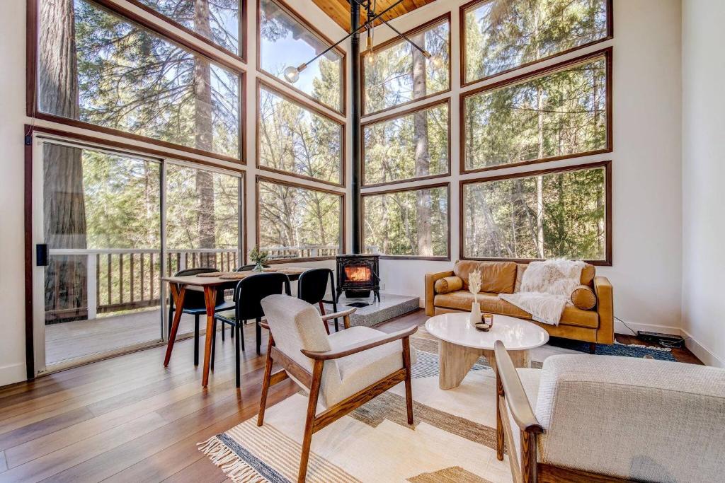 un soggiorno con una grande stanza con finestre di Glass Cabin Under the Pines | Hot Tub • Seclusion a Willow Valley