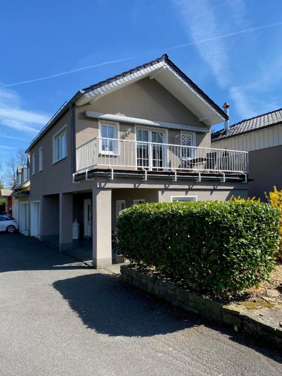 a large house with a balcony and bushes at Gemütliche 2 Zimmerwohnung in Wuppertal