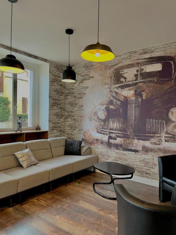 un salon avec un canapé et un tableau au mur dans l'établissement L'univers automobile au coeur de Mulhouse, à Mulhouse