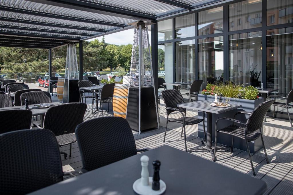 an outdoor patio with tables and chairs and windows at Hotel reSTART Superior in Jičín