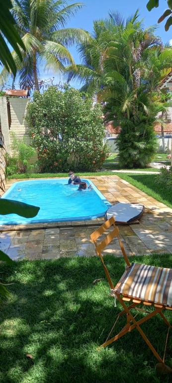 einen Pool mit 2 Liegestühlen und einem Pool in der Unterkunft O melhor lugar pra família, em Tamandaré in Tamandaré