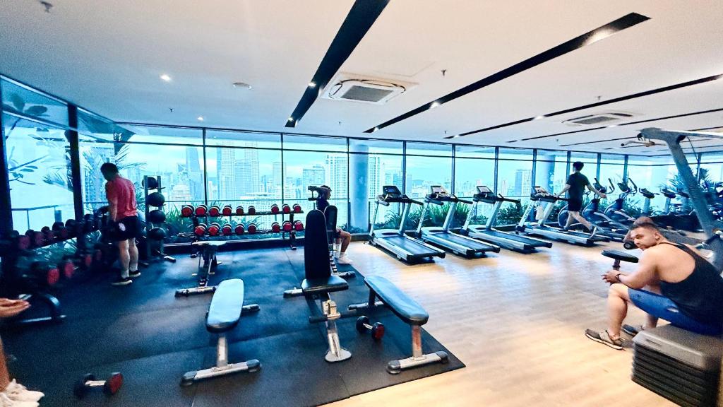a gym with people exercising on treadmills at Colony Service Suites Kuala Lumpur in Kuala Lumpur
