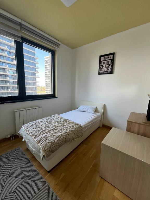 a bedroom with a bed and a large window at BW St Lui Apartment in Belgrade