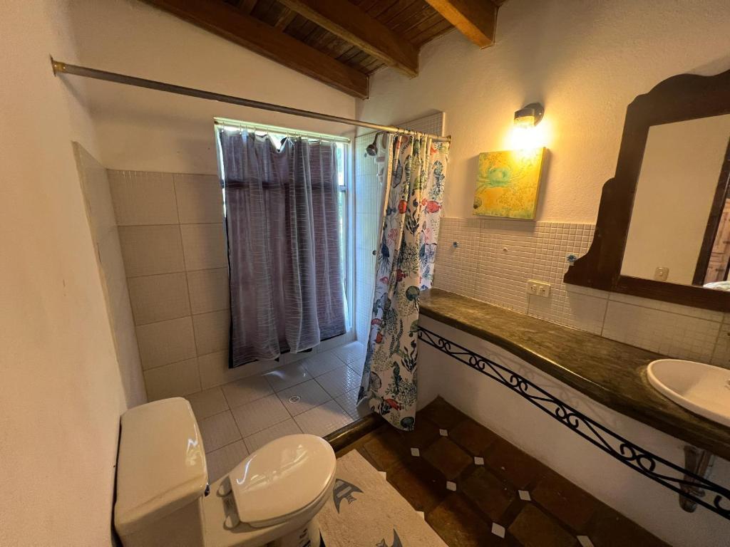 a bathroom with a toilet and a sink at Villa Vitali - Casa vacacional con Piscina y Jardines en Morrocoy para 14 personas in Tucacas