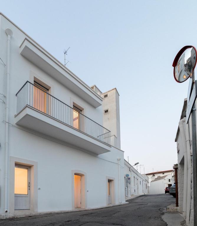 un immeuble blanc avec un balcon dans une rue dans l'établissement Dimore Trulli Holiday, à Alberobello