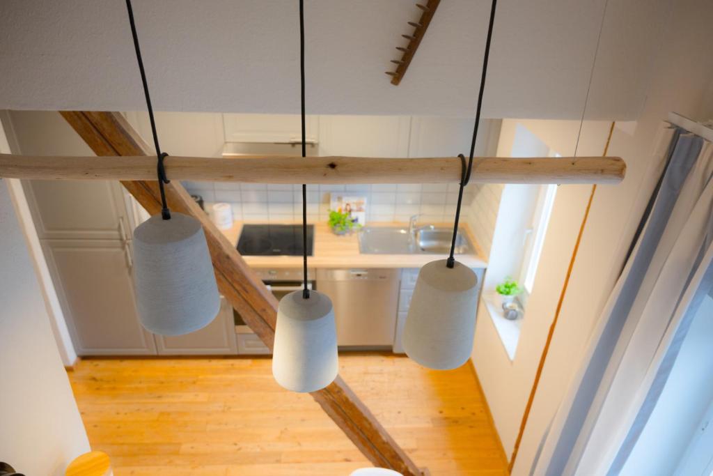 un gruppo di cinque luci bianche appese a un soffitto di Ferienwohnung Brise - Inselhof Fehmarn a Fehmarn