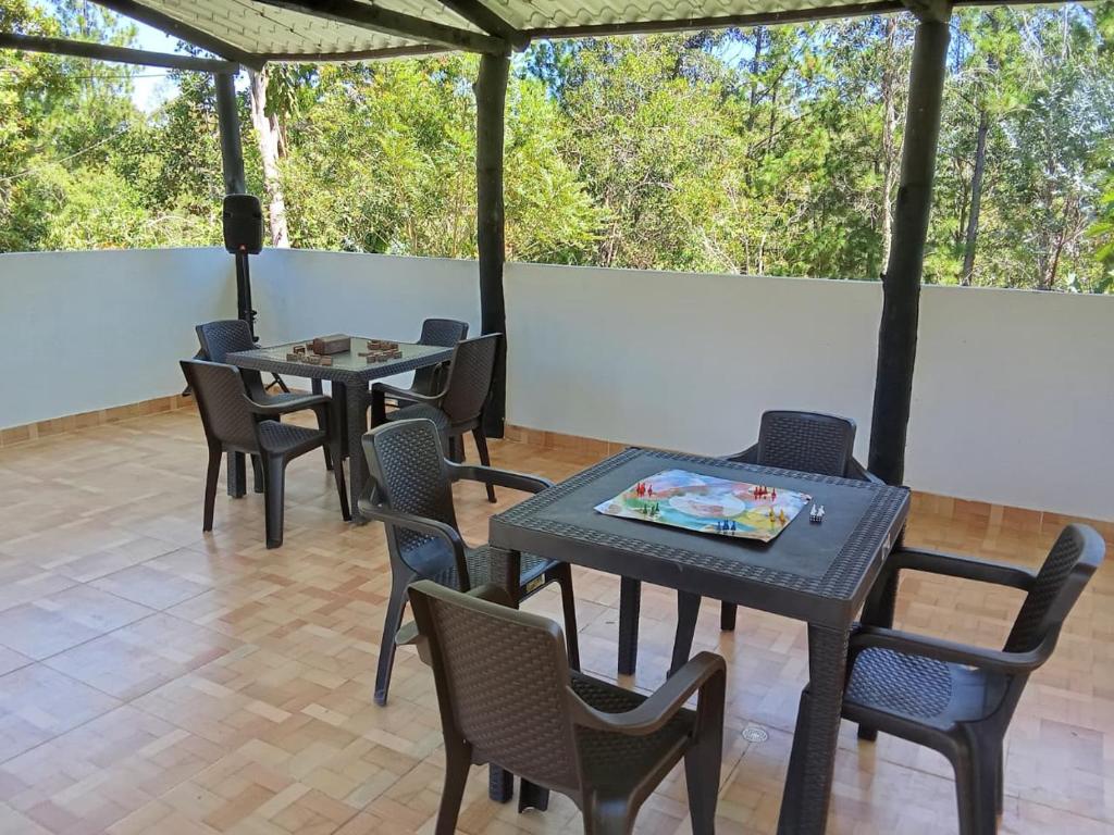 due tavoli e sedie su un patio con alberi di HOSPEDAJE CAMPESTRE VILLA PARAISO a Curití