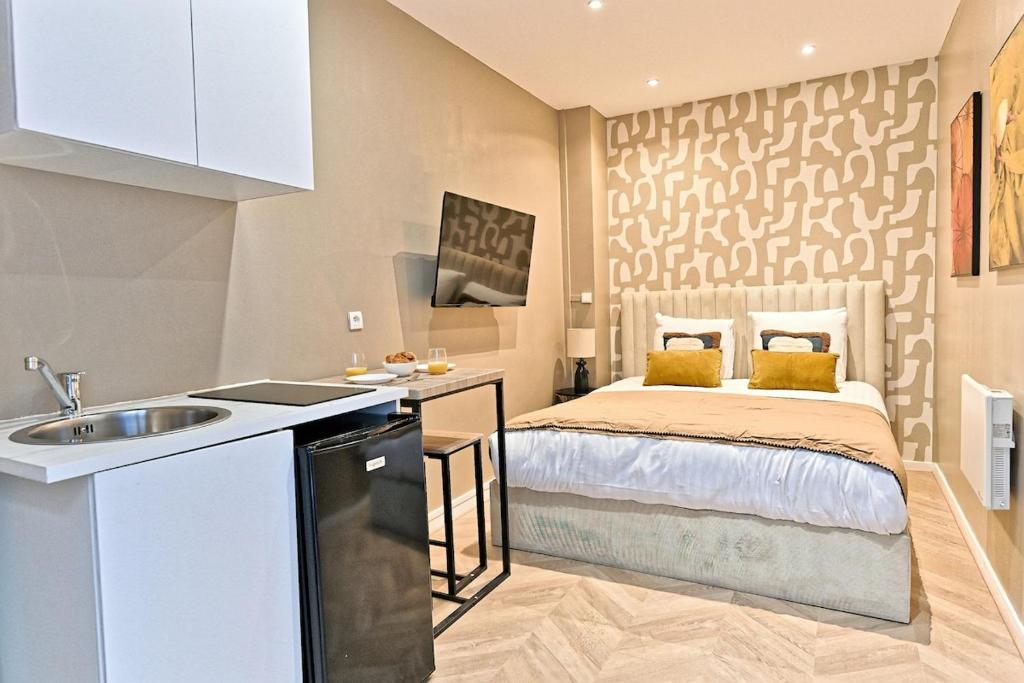 - une cuisine avec un lit et un évier dans la chambre dans l'établissement Studio situé dans le 11ème arrondissement, à Paris