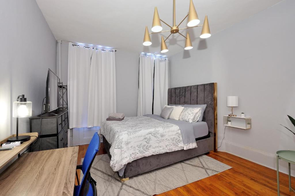 a bedroom with a bed and a desk and a television at Spacious Upper East Side Studio in New York