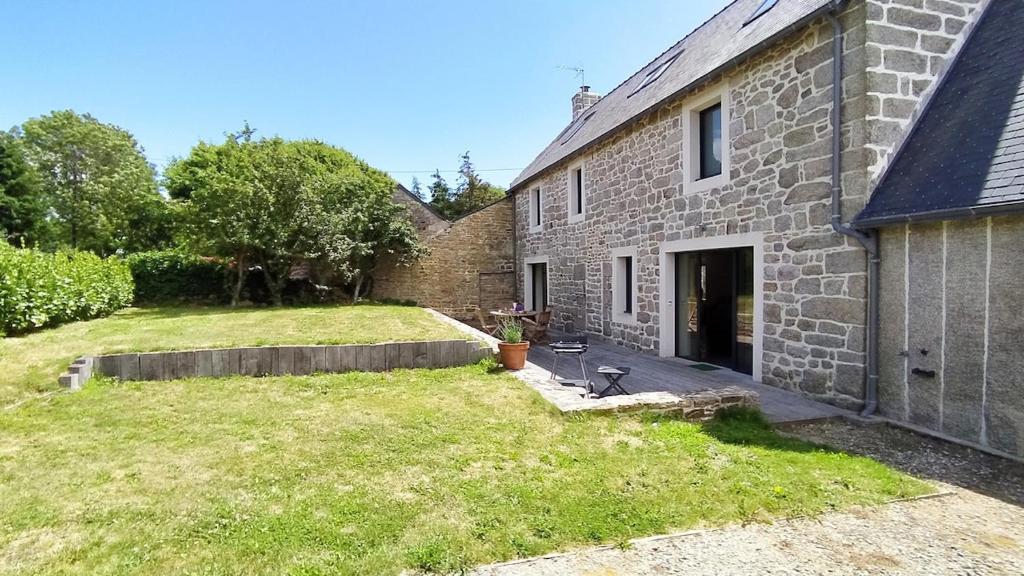 - une vue extérieure sur une maison en briques avec une cour dans l'établissement Maison de famille entre campagne et océan, Bretagne Trévignon, à Trégunc