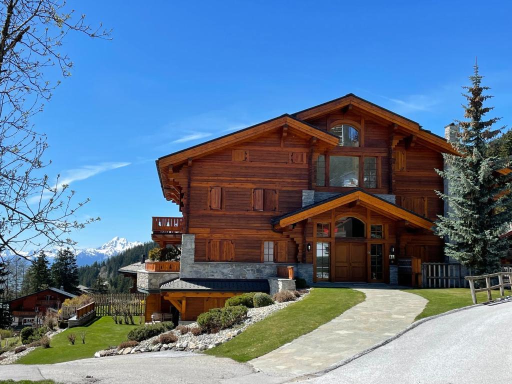 a large wooden house with a driveway at Charme assuré in Crans-Montana