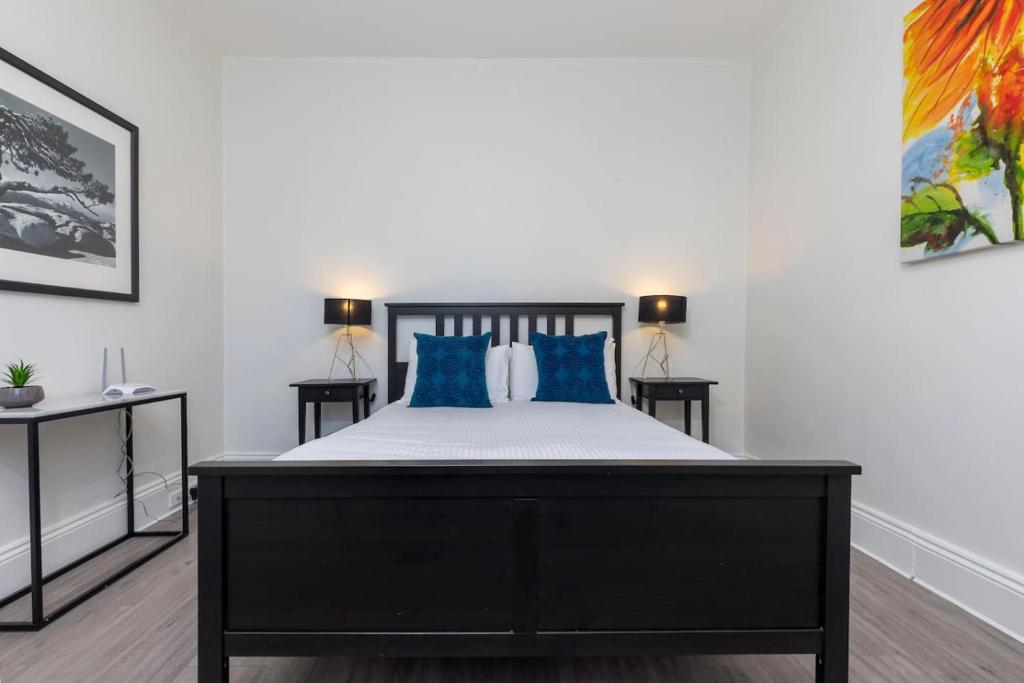 Un dormitorio con una cama grande con almohadas azules. en Charming 1 bedroom, park adjacent. city 5 minutes, en Sídney