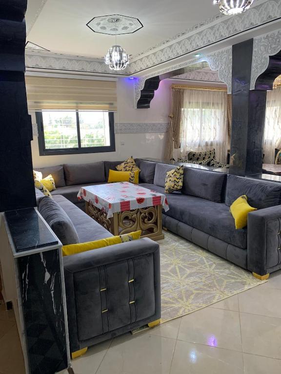 a living room with a blue couch and yellow pillows at Al confort in Fez