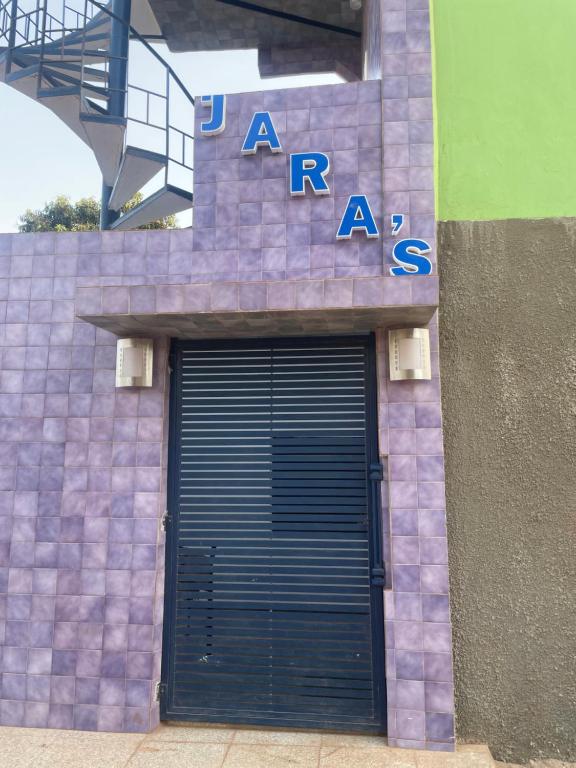a building with a garage door with a sign on it at Jaras in Serekunda