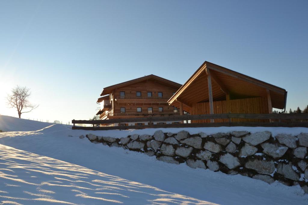 una casa en la nieve con una pared de piedra en Winklerhof Ebbs, en Ebbs