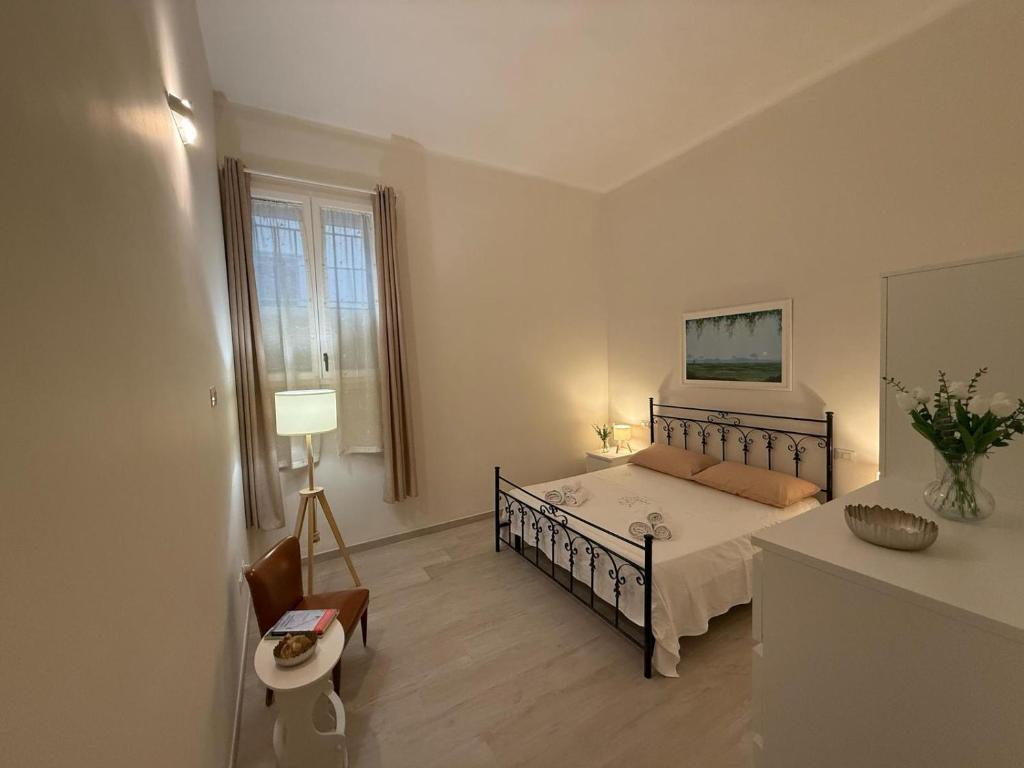 een slaapkamer met een bed, een stoel en een raam bij Casa nel vicolo in Trani