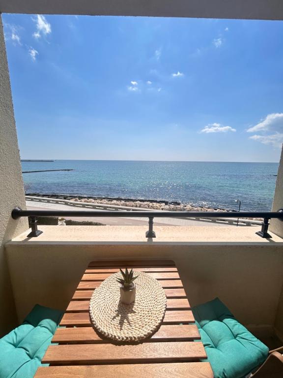 Una mesa en un balcón con vista a la playa. en Infinity Blue Apartment-Complex Carpe Diem - FREE PARKING, en Balchik