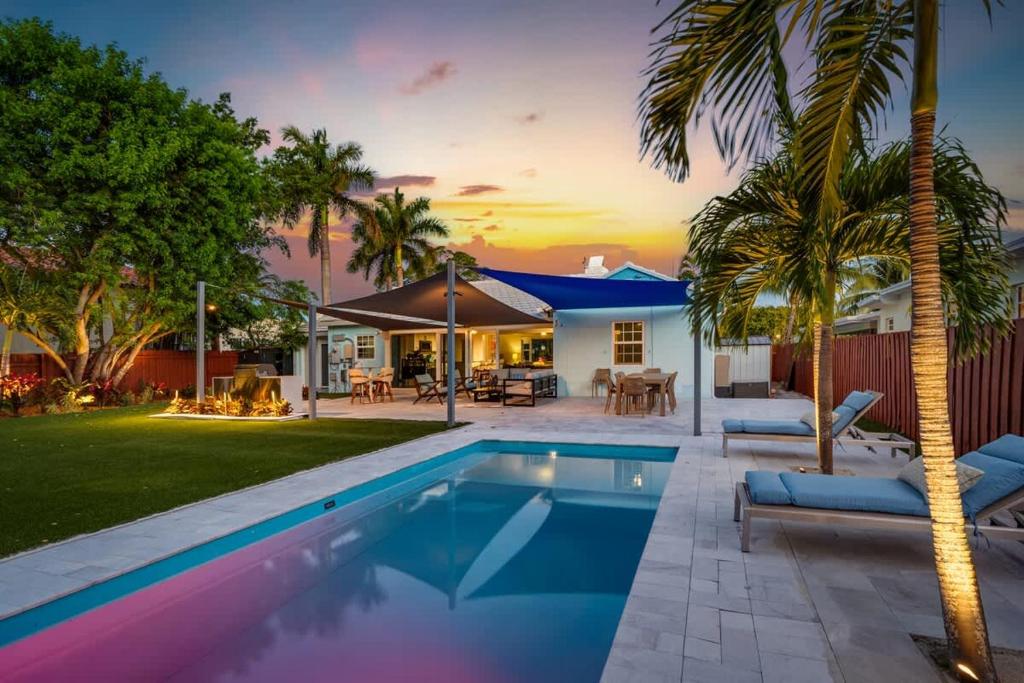 Un patio trasero con piscina y una casa. en Pool and Spacious Backyard - Delray Beach Home, en Delray Beach